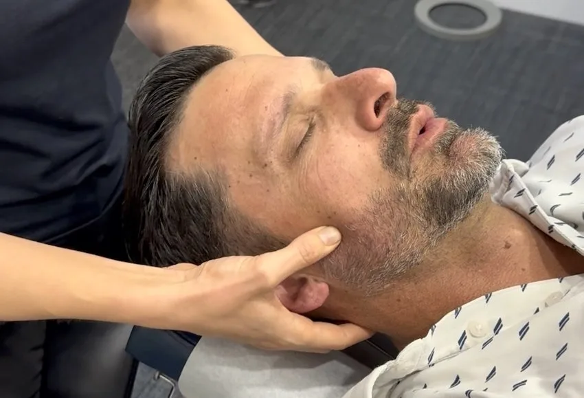 Practitioner treating a patient's jaw and neck